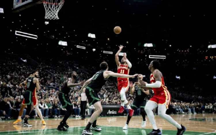 Pemain bintang Atalanta Hawks, Trae Young (tengah), melakukan tembakan sambil melayang di udara atau floater saat melawan Boston Celitcs di TD Garden Arena, Boston, Massachusetts. (ANTARA/Getty Images via AFP/MADDIE MALHOTRA)