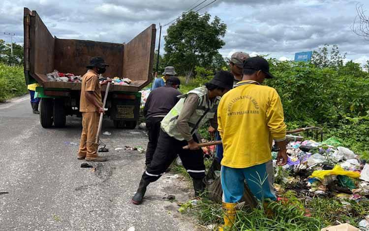 Tim DLH saat membersihkan sampah di Jalan G. Obos XXIV, tepatnya di depan Gang Raden Muda (Foto:DLH untuk Borneonews)