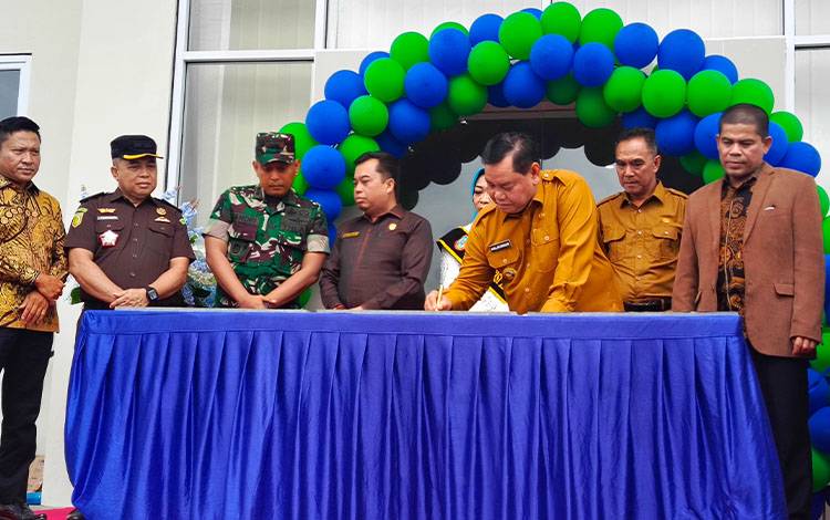 Bupati Kotim Halikinnor saat menandatangani prasasti pembangunan dan peralihan nomenklatur sejumlah SD, Senin, 20 Januari 2025. (FOTO : DEVI)