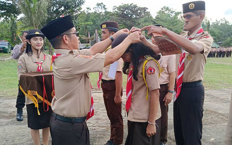 Penjabat (Pj) Sekretaris Daerah (Sekda) Kabupaten Barito Timur, Misnohartaku, menyematkan tanda peserta secara simbolis saat membuka kegiatan Kemah Penggalang, Kemah Penegak dan Pesta Siaga Kwartir Cabang (Kwarcab) Gerakan Pramuka Barito Timur di Bumi Perkemahan Bangi Wao, Jumat, 24 Januari 2025. (FOTO: AGUSTUS BOLE MALO)