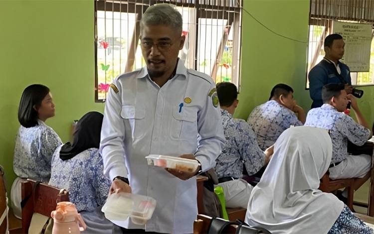 Kepala Dinas Pendidikan Kota Palangka Raya, Jayani saat membagikan makan bergizi gratis. (FOTO: HUMAS)
