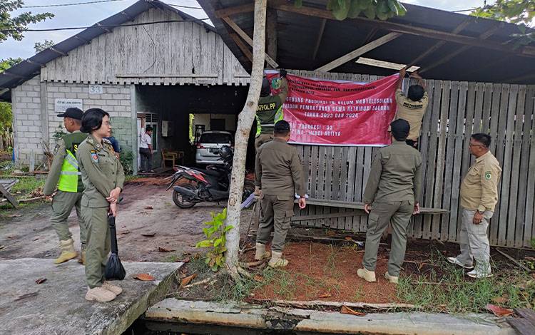 Tim gabungan Satpol PP dan DPKUKMP Palangka Raya saat memasang spanduk peringatan retribusi (Foto : DPKUKMP Palangka Raya)