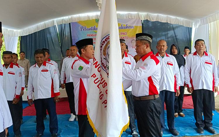 Ketua DPC Abpednas Pulang Pisau Karlulyn menyerahkan bendera petaka kepada Ketua PAC Abpednas Pandih Batu, Kamis, 13 Febuari 2025. (FOTO: RETHA)