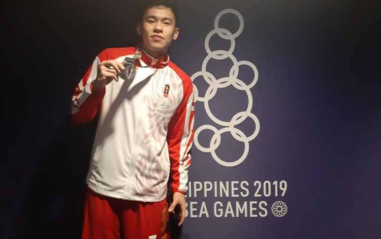 Rivaldo Tandra Pangesthio saat memperkuat tim basket 3x3 Indonesia, menunjukkan medali perak yang direbut skuatnya dalam SEA Games 2019 di Filoil Flying Arena, Manila, Senin (2/12/2019). Indonesia mendapatkan perak setelah kalah 9-21 dari Filipina di final. (Michael Siahaan)