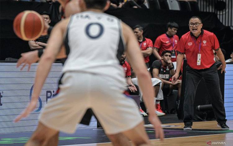 Pelatih Timnas Basket Indonesia Johannis Winar (kanan) memberikan insturksi kepada anak asuhnya saat melawan tim basket Korea Selatan dalam pertandingan kualifikasi FIBA Asia Cup 2025 di Indonesia Arena, Kompleks Gelora Bung Karno (GBK), Jakarta, Minggu (23/2/2025). ANTARA FOTO/Fauzan/tom.