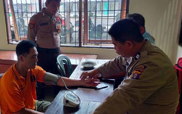 Tersangka Salundik Uhing saat menjalani pemeriksaan kesehatan di Mapolres Seruyan. (Foto: Ist)