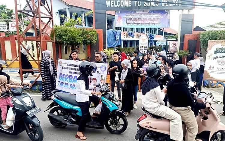 Keluarga besar SDN 5 Melayu Muara Teweh bersama Intan Pariwara, Komite Sekolah dan orang tua siswa membagikan takjil (makanan dan minuman untuk berbuka puasa) kepada para pengguna jalan di depan SDN 5 Melayu, Sabtu, 8 Maret 2025. (Foto: Dhani)