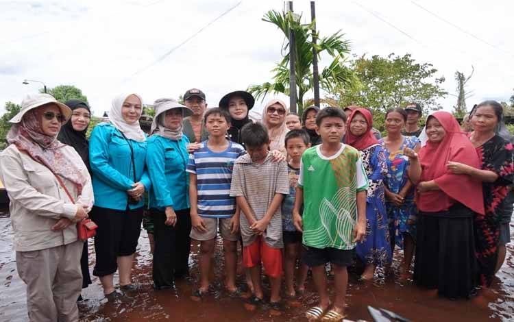 Ketua TP PKK Kalteng, Aisyah Thisia Agustiar Sabran bersama masyarakat terdampak banjir di Palangka Raya. (FOTO:AD)