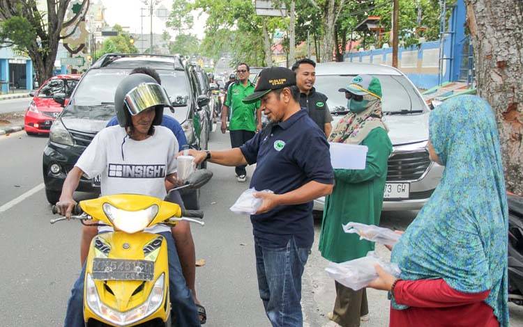 Ketua RAPI Wilayah 03 Kobar Rachmat Sony saat membagikan takjil kepada pengendara, Selasa, 18 Maret 2025.