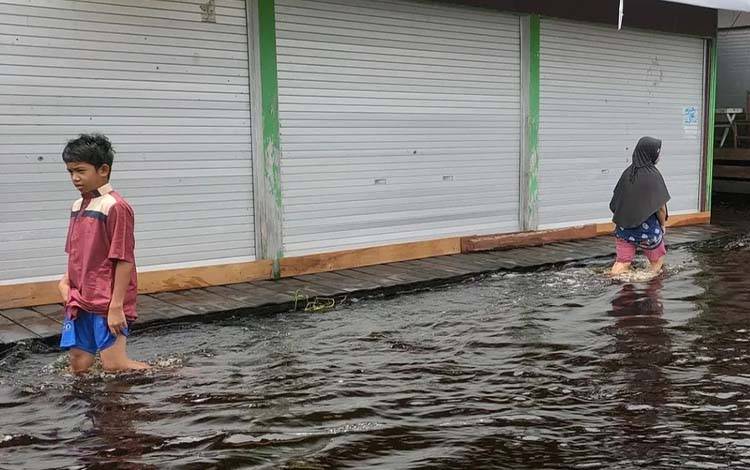Aktivitas warga jalan Mendawai di tengah banjir, Minggu, 23 Maret 2025. (Foto : PATHUR)