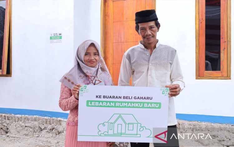 Mustahik asal Lebak, Banten bernama Amin (kanan) bersama istrinya berfoto bersama di depan rumah yang baru direnovasi oleh Badan Amil Zakat Nasional (Baznas) RI, melalui Program Rumah Layak Huni Baznas. ANTARA/HO-Baznas RI