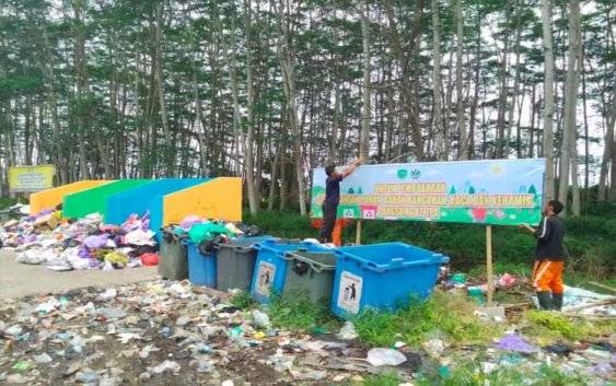 Petugas kebersihan DLHK saat memasang spanduk imbauan di TPS rei 3, Rabu 16 April 2025.( FOTO : RETHA )?