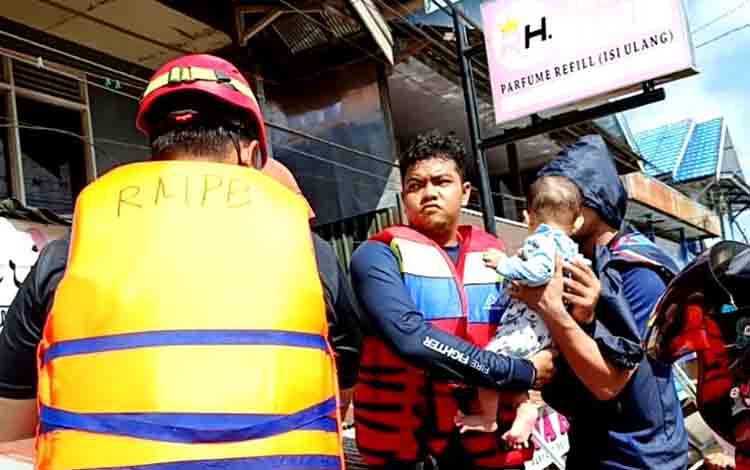 Anggota Disdamkarmat Barito Utara melakukan evakuasi warga terdampak banjir di beberapa titik lokasi dalam kota Muara Teweh. (Foto: Dhani)