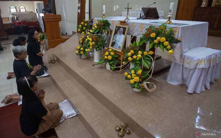 Petugas berdoa di dekat foto Paus Fransiskus di Gereja Katolik St. Maria Assumpta Gamping, Sleman, D.I Yogyakarta, Selasa (22/4/2025). ANTARA FOTO/Andreas Fitri Atmoko/rwa