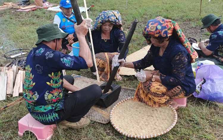 Aktivitas masyarakat sedang bekerja sama menumpuk padi (Foto:MARINI)