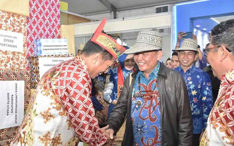 Gubernur Kalteng Agustiar Sabran (kedua kanan) pejabat lainnya kunjungi stand UMKM Barito Utara yang disambut hangat Pj Bupati Barito Utara Muhlis (kiri) di Palangka Raya, Minggu (18/5/2025) malam.ANTARA/HO-Dinas Kominfosandi Barito Utara