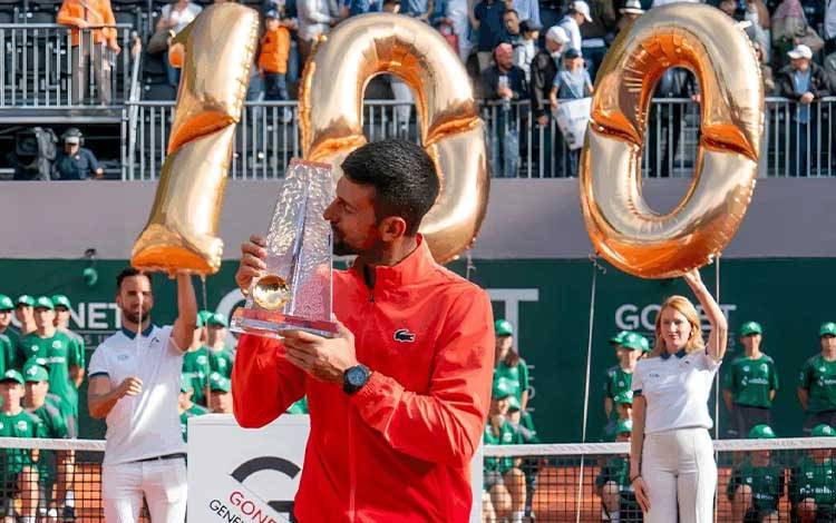 Petenis Serbia Novak Djokovic mencium trofi yang sekaligus merupakan gelar ke-100 dalam kariernya usai mengalahkan petenis Polandia Hubert Hurkacz pada final Gonet Geneva Open di Jenewa, Swiss, Sabtu (24/5/2025). (Gonet Geneva Open)