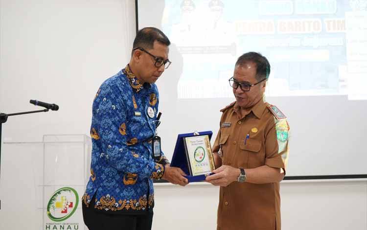 Direktur UPT RSUD Hanau, dr. Atet Kurniadi?menyerahkan plakat kepada Pj Sekda Bartim, Misnohartaku ?saat kunjungan di RSUD Hanau (Foto : Ist)