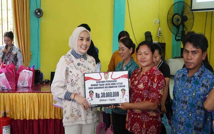 Ketua Tim Pembina Posyandu Kalteng, Aisyah Thisia Agustiar Sabran menyerahkan bantuan secara simbolis. (FOTO:SETDA KALTENG)