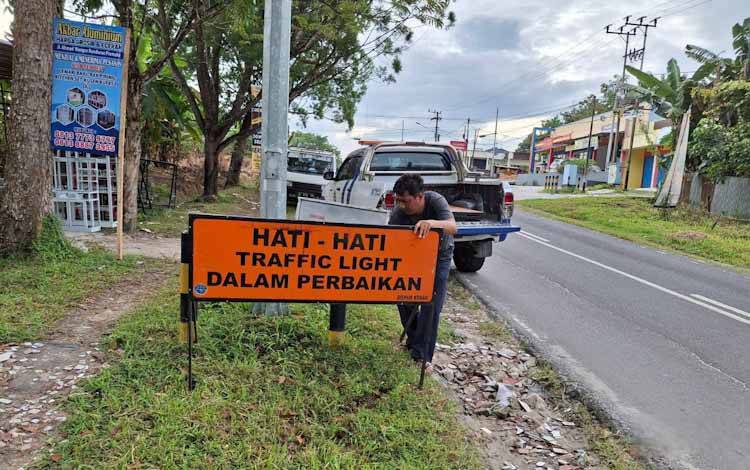 Petugas Dishub Kobar sedang memasang papan pemberitahuan terkait kerusakan traffic light di persimpangan Jalan Samari, Pangkalan Bun