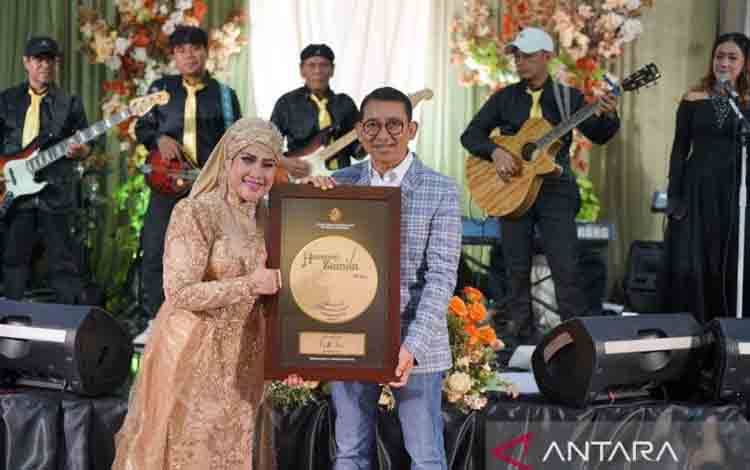 Penyanyi Elvi Sukaesih (kiri) saat menerima penghargaan dari Menteri Kebudayaan Fadli Zon (kanan). ANTARA/ (HO-Kementerian Kebudayaan)