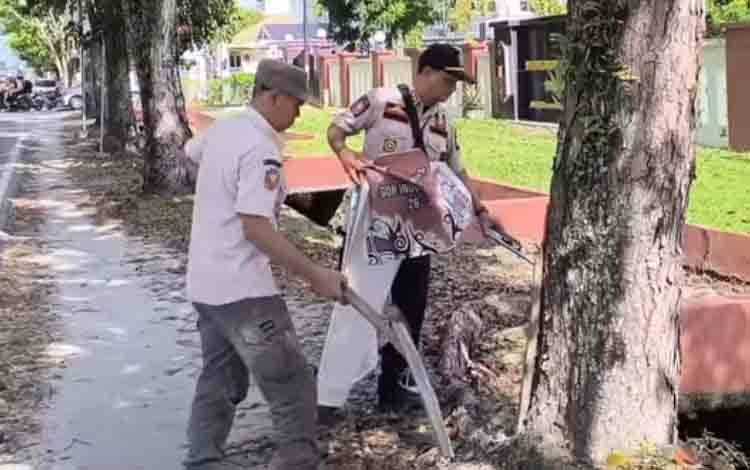 Penertiban reklame liar yang dipasang di pepohonan. (FOTO: SATPOLPP KALTENG)