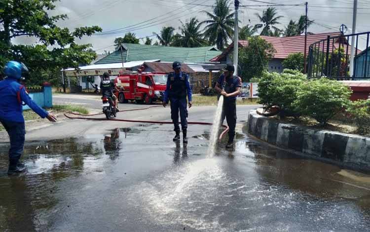 Petugas Damkar saat melakukan upaya pembersihan tumpahan minyak solar di sekitar Bundaran KB ( Foto : Ist)