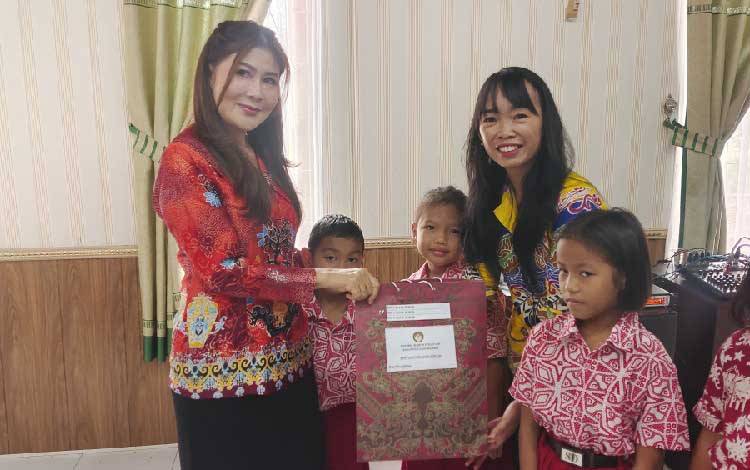 Ketua DWP Kabupaten Gunung Mas Susie Andrianie Richard saat menyerahkan bantuan peralatan sekolah kepada siswa, Kamis, 17 Juli 2025. (FOTO: DISKOMINFOSANTIK GUMAS)