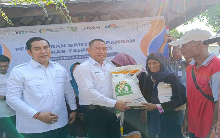 Pimpinan cabang Bulog Kapuas Akhmad Ronni Anwar menyerahkan beras kepada masyarakat penerima manfaat, Rabu 23 Juli 2025.( FOTO : RETHA )