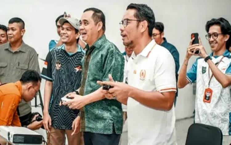 Asisten Bidang Pemerintahan dan Kesejahteraan Rakyat (Asisten I) Sekretariat Daerah Kabupaten Kapuas, Romulus ketika menjajal salah satu gim konsol di? pembukaan Turnamen Esport Bupati Cup 2025 yang digelar di Hall CitiMall Lt. 2 Kuala Kapuas, Kamis malam, 31 Juli 2025. (IST)