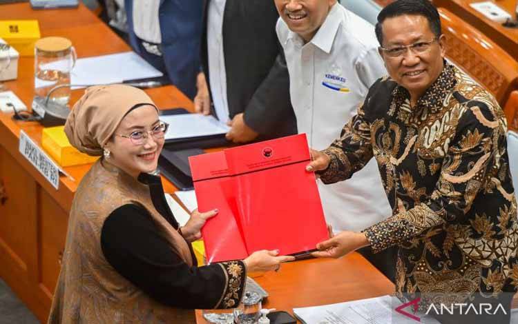 Menteri Hukum Supratman Andi Agtas (kanan) menerima pandangan fraksi dari Anggota Komisi VIII DPR Fraksi PDI Perjuangan Selly Andriany Gantina (kiri) saat rapat kerja bersama Komisi VIII DPR di Kompleks Parlemen, Senayan, Jakarta, Senin (25/8/2025). Komisi VIII DPR bersama perwakilan dari Pemerintah menyetujui agar Rancangan Undang-Undang (RUU) tentang Perubahan atas Undang-Undang Nomor 8 Tahun 2019 tentang Penyelenggaraan Haji dan Umrah dibawa ke rapat paripurna. ANTARA FOTO/Rivan Awal Lingga/r