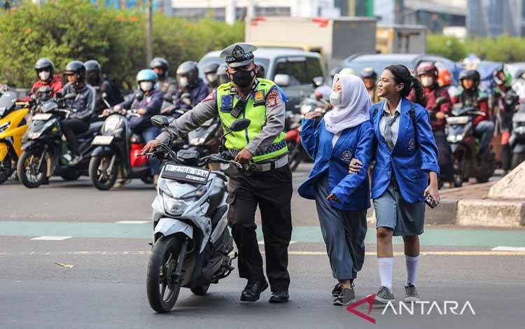 Anggota kepolisian membawa motor pengendara yang melanggar peraturan saat Operasi Patuh Jaya 2024 di Jalan Letjen S Parman, Jakarta, Senin (15/7/2024). Polda Metro Jaya menggelar Operasi Patuh Jaya 2024 secara simpatik dan humanis selama 14 hari dari 15 - 28 Juli 2024 dengan 14 target operasi pelanggaran. ANTARA FOTO/Asprilla Dwi Adha/rwa.