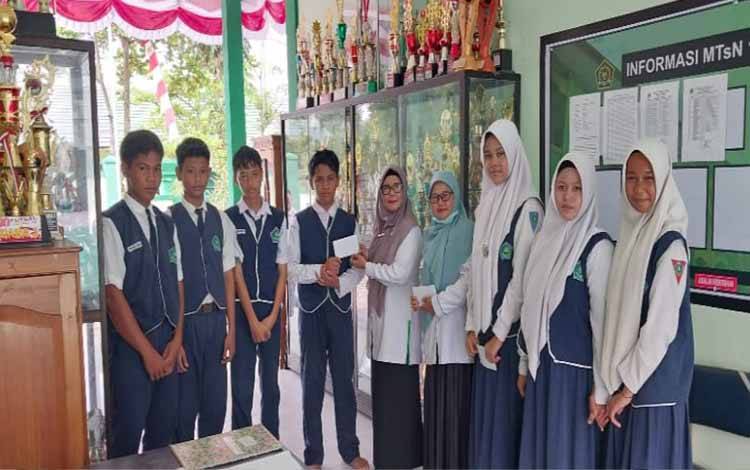 Penyerahan bantuan dari UPZ ke sejumlah siswa kurang mampu di MTsN 1 Kapuas, Selasa, 16 September 2025. (FOTO. MTsN 1 Kapuas)