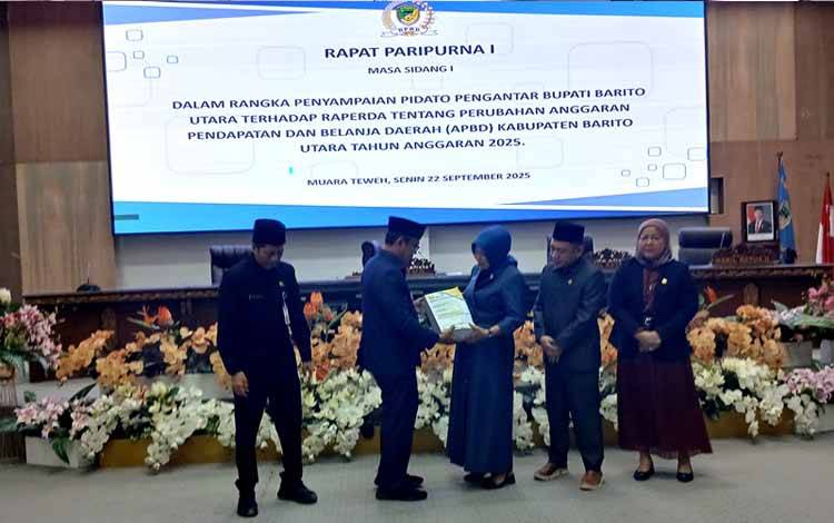 Pj Bupati Barito Utara, Indra Gunawan menyerahkan materi rapat terhadap Raperda Perubahan APBD, Senin 22 September 2025. (foto: Dhani)