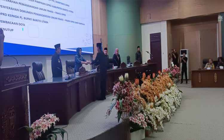 Juru bicara Fraksi Demokrat DPRD Barito Utara, Patih Herman AB saat menyerahkan pemandangan umum fraksi kepada pimpinan sidang.(foto: Dhani)