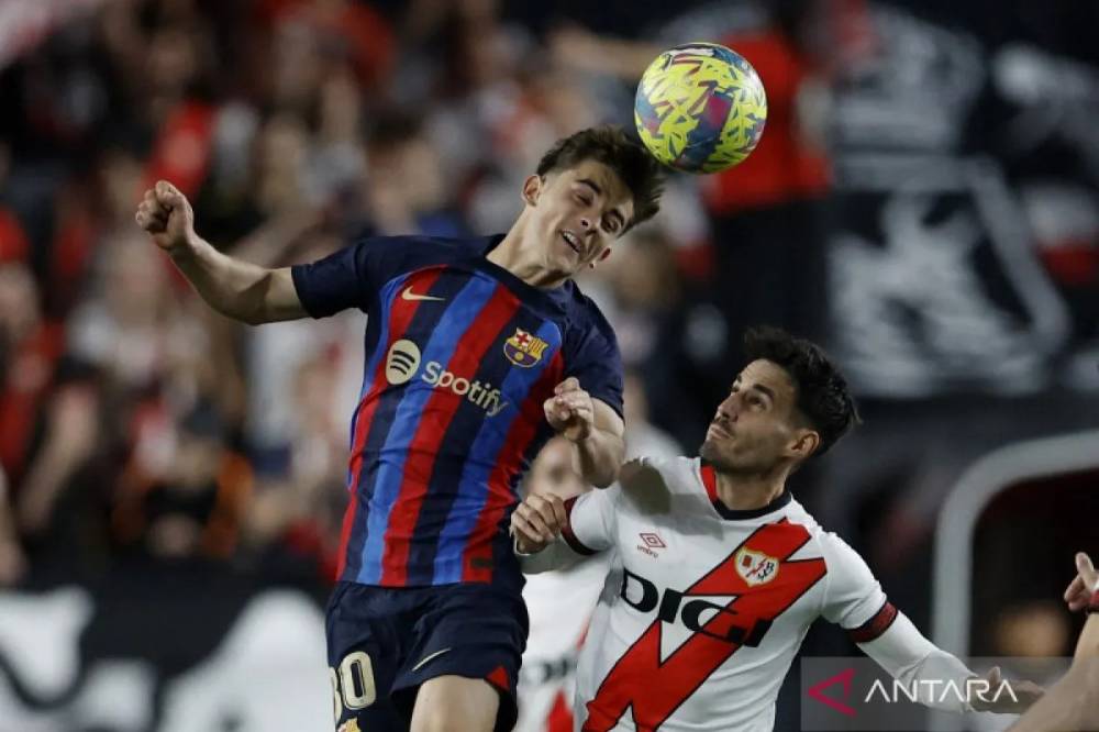 Arsip - Pesepak bola Barcelona Gavi menyundul bola dibayangi pemain Rayo Vallecano Oscar Valentin dalam laga lanjutan Liga Spanyol di Campo de Futbol de Vallecas, Madrid, Spanyol, Rabu (26/4/2023). ANTARA FOTO/REUTERS/Juan Medina/foc.