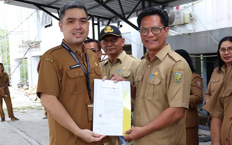 Sekretaris Dinas Pendidikan Palangka Raya Aprae Vico Ranan saat menyerahkan SK kenaikan pangkat kepada salah satu guru (Foto : IST)