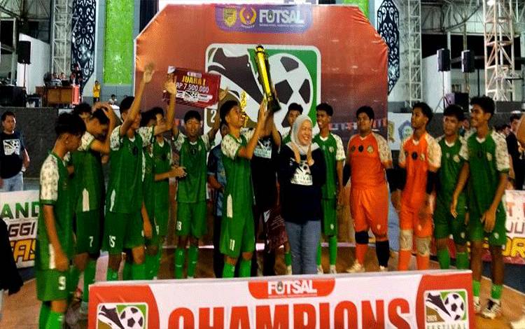 Staf Ahli Bupati Bidang Politik dan Hukum, Drs H Ardian didampingi Ketua AFK Barito Utara sekaligus Ketua KONI dan Waket II DPRD Hj Henny Rosgiaty Rusli menyerahkan piala kepada juara Festival Futsal Antar Pelajar SMA sederajat se Barito Utara, Senin malam 20 Oktober 2025. (foto: Dhani)