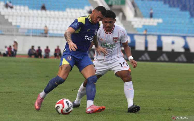 Pesepak bola Arema FC Paulo Roberto Moccelin (kiri) berusaha melewati hadangan pesepak bola Borneo FC Muhammad Fajar Fathurahman (kanan) dalam pertandingan BRI Super League 2025 di Stadion Kanjuruhan, Malang, Jawa Timur, Minggu (26/10/2025). Borneo FC menang atas Arema FC dengan skor akhir 3-1. ANTARA FOTO/ARI BOWO SUCIPTO