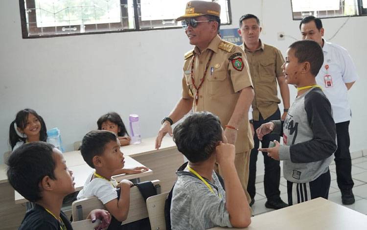 Gubernur Kalimantan Tengah (Kalteng), Agustiar Sabran saat bercengkrama bersama anak-anak di sekolah rakyat. (FOTO: DISDIK KALTENG)
