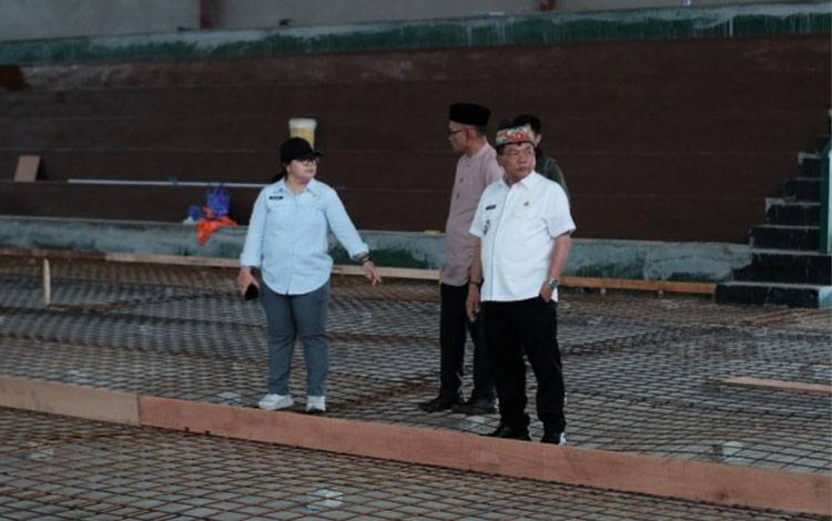 Bupati Kapuas, M. Wiyatno, didampingi oleh Kepala Dinas Pekerjaan Umum dan Penataan Ruang (PUPR) Kabupaten Kapuas, Hargatin, meninjau langsung progres pekerjaan rehabilitasi Gedung Olah Raga (GOR) Panunjung Tarung pada Jumat, 31 Oktober 2025. (FOTO: Diskominfo Kps)