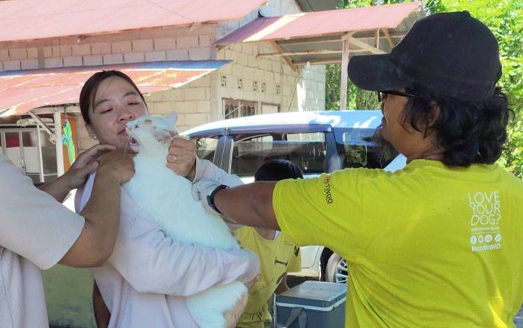 Vaksinator memberikan vaksin rabies kepada warga Panarung pada Sabtu, 1 November 2025. (FOTO: TESTI PRISCILLA)