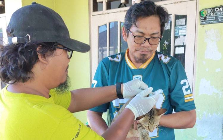 Vaksinator memberikan vaksin rabies kepada warga Panarung pada Sabtu, 1 November 2025. (FOTO: TESTI PRISCILLA)