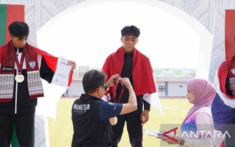 Atlet Indonesia Nixon Simangunsong saat pengalungan medali usai meraih emas dari nomor lompat jangkit ANTARA/Juraidi