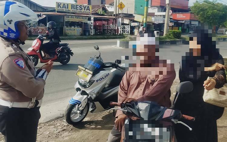 Personel Ditlantas Polda Kalteng saat menegur secara humanis pengendara yang tidak menggunakan helm. (Foto : IST)