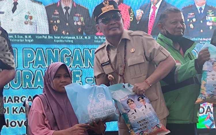 Gubernur Kalimantan Tengah Agustiar Sabran saat memberikan paket sembako kepada masyarakat. (FOTO: HERMAWAN)