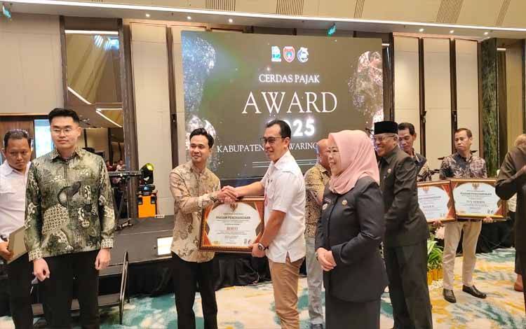 Kepala Bapenda Kobar Nursyah Ihsan saat memberikan penghargaan kepada wajib pajak dalam kegiatan 'Cerdas Pajak Awards 2025'. (Foto : DANANG)