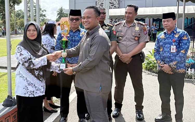 Ketua DPRD Barito Timur, Nursulistio ikut menyerahkan piagam dan piala penghargaan kepada Guru Berprestasi Tingkat Kabupaten Barito Timur, Senin, 1 Desember 2025. (FOTO: IST)