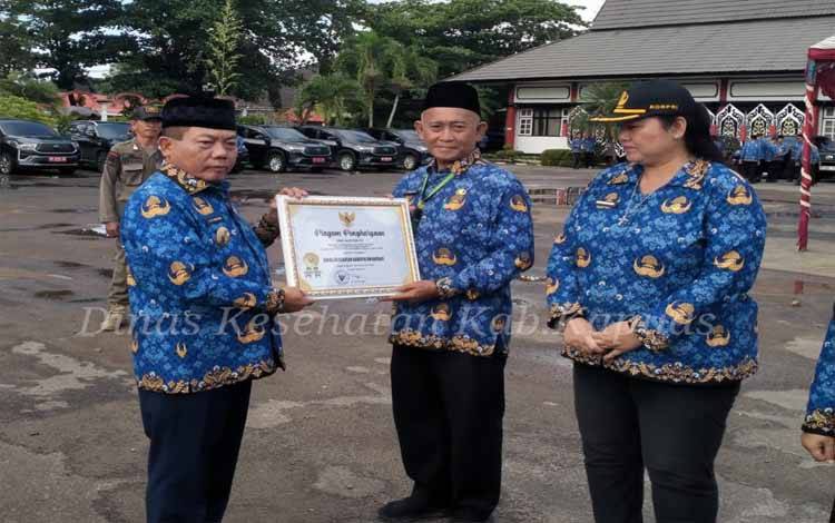 Dinkes Kapuas saat menerima penghargaan Tingkat Kematangan Organisasi dan Evaluasi Sistem Akuntabilitas Kinerja Instansi Pemerintah (SAKIP) dalam peringatan HUT KORPRI di Kantor Bupati Kapuas, Senin, 1 Desember 2025. (FOTO: Diskominfo Kps)