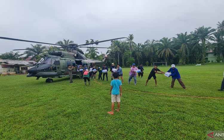 TNI bersama masyarakat memindahkan bantuan kepada korban terdampak bencana yang diangkut menggunakan helikopter di Sumatera Barat. Antara/HO-Humas Lanud Sutan Sjahrir